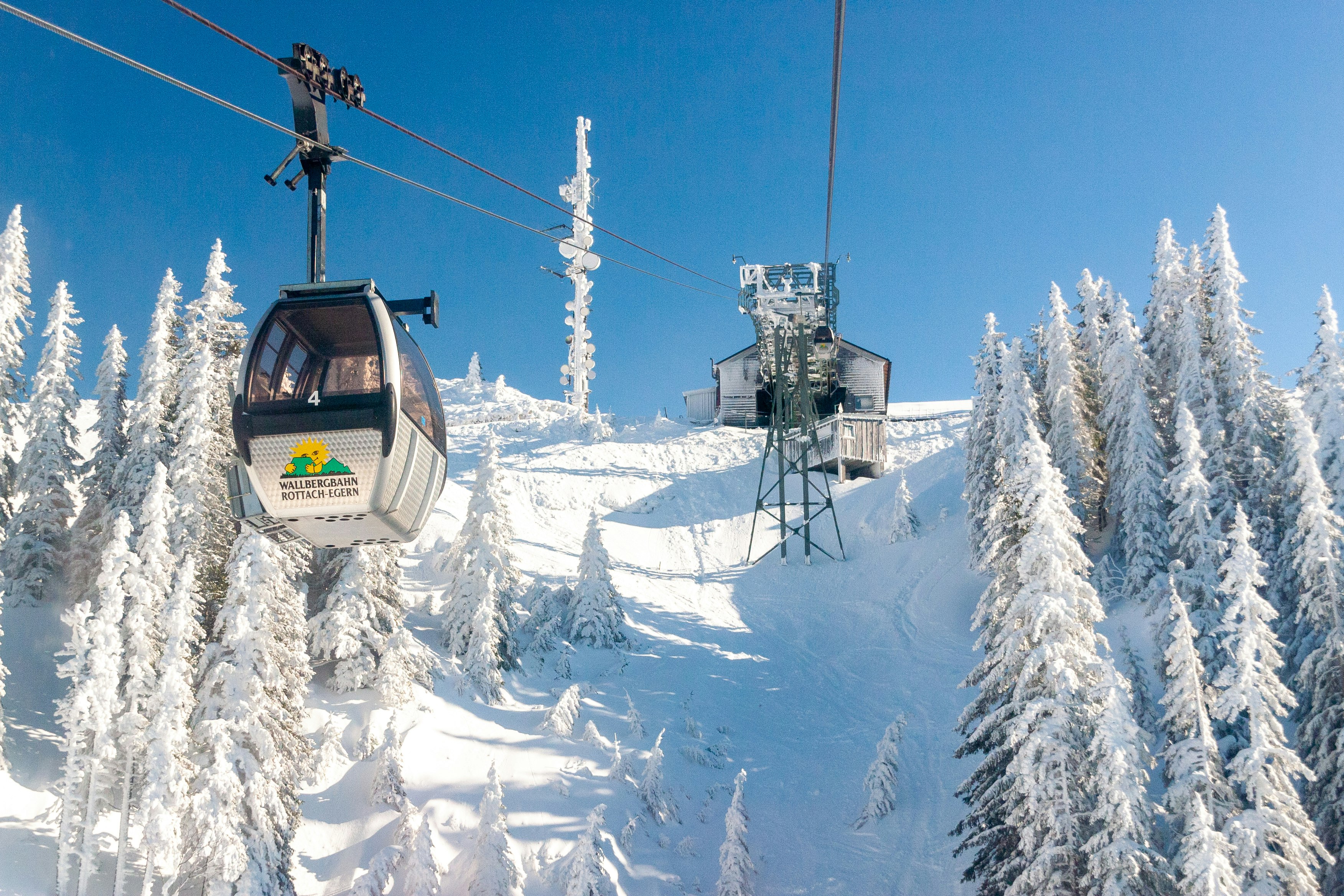 white and black cable car over snow covered mountain during daytime